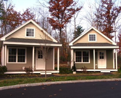 First step cottages at Ridgeline Community. These cottages are in various muted shades of brown and green with trees in various stages of autumnal color changes.