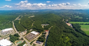 Aerial View of Pine Hill in North Conway, NH on a spring/summer day. Bright green trees surround the commercial buildings and parking lots.